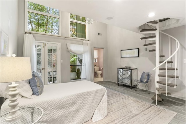 695 Kiskatom Ln, Mandeville, LA 70471 - bedroom featuring wood finished floors, a high ceiling, baseboards, access to outside, and connected bathroom
