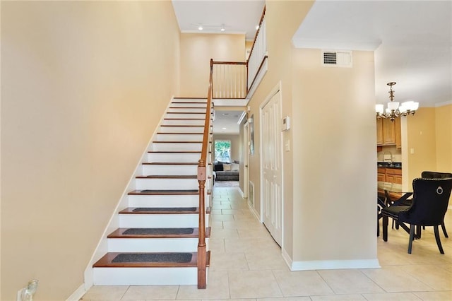 107 10th St Unit 107, New Orleans, LA 70124 - stairway with tile patterned flooring, baseboards, a chandelier, and a high ceiling
