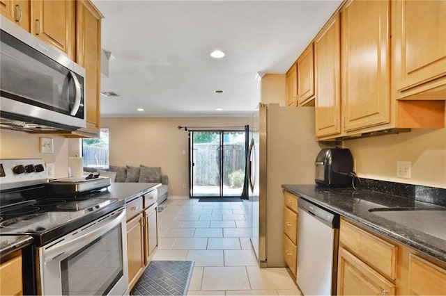 107 10th St Unit 107, New Orleans, LA 70124 - kitchen featuring appliances with stainless steel finishes, healthy amount of natural light, light tile patterned flooring, dark stone counters, and recessed lighting