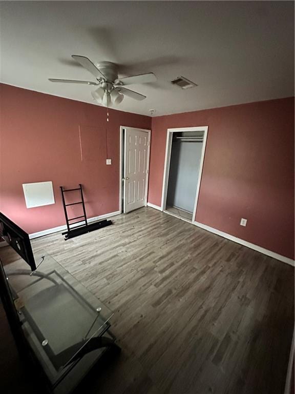 spare room with wood finished floors, baseboards, and a ceiling fan