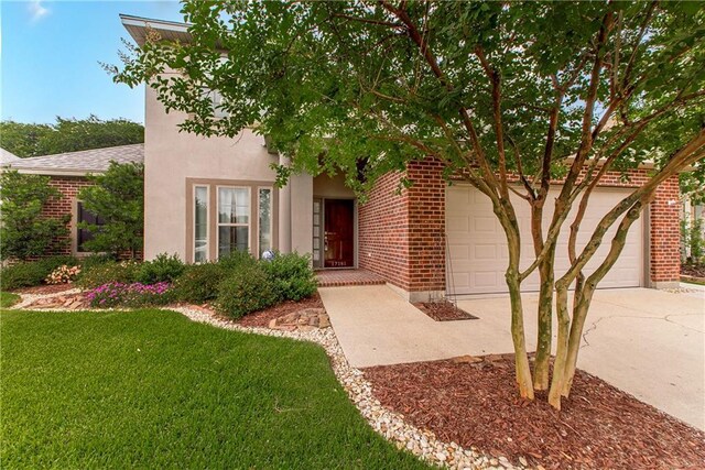 17181 Bridle Path, Hammond, LA 70403 - view of property hidden behind natural elements featuring driveway, a front yard, brick siding, and a garage