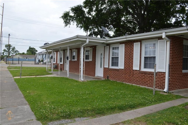 4133 Pauger St, New Orleans, LA 70122 - ranch-style home with a porch, a front lawn, and brick siding