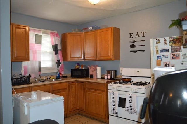 4133 Pauger St, New Orleans, LA 70122 - kitchen featuring white appliances, a sink, light countertops, light tile patterned flooring, and brown cabinetry