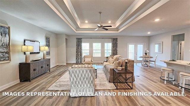 living room with wood finished floors, ornamental molding, a raised ceiling, recessed lighting, and baseboards