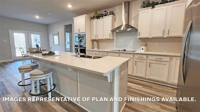 kitchen with wall chimney range hood, appliances with stainless steel finishes, light wood-type flooring, backsplash, and recessed lighting