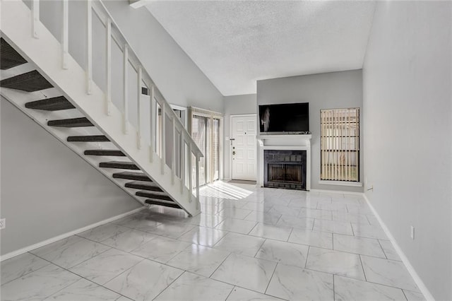 2912 Manhattan Blvd Unit 133, Harvey, LA 70058 - stairway featuring baseboards, a fireplace, marble look tile flooring, a textured ceiling, and vaulted ceiling