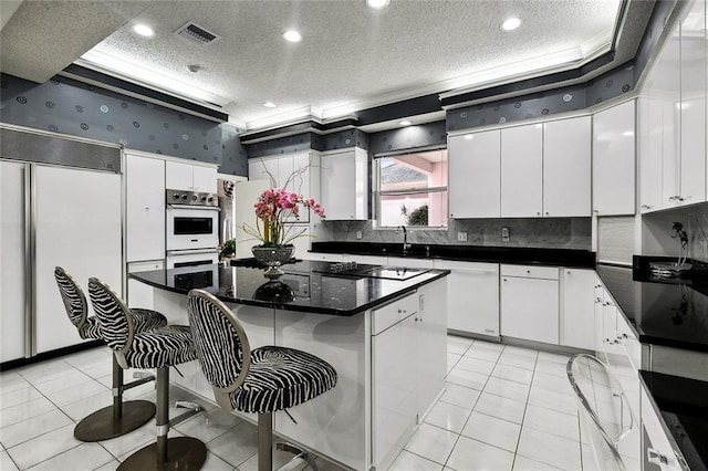 3805 3rd St, Metairie, LA 70002 - kitchen featuring white appliances, a textured ceiling, white cabinetry, dark countertops, and crown molding