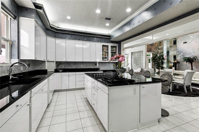 3805 3rd St, Metairie, LA 70002 - kitchen with a sink, light tile patterned flooring, dark countertops, decorative backsplash, and white cabinetry