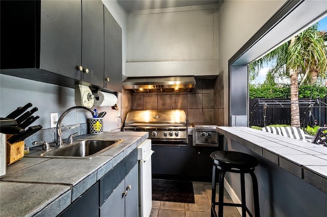 3805 3rd St, Metairie, LA 70002 - kitchen with a sink, extractor fan, tile counters, decorative backsplash, and a kitchen breakfast bar