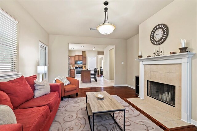 living area featuring wood finished floors, a fireplace, and baseboards
