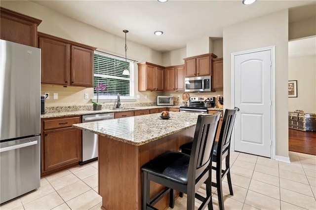 kitchen with appliances with stainless steel finishes, a sink, light tile patterned floors, a breakfast bar area, and recessed lighting