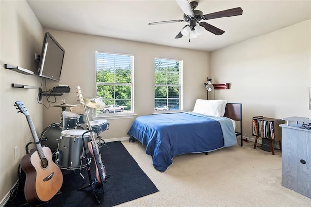 carpeted bedroom with a ceiling fan and baseboards