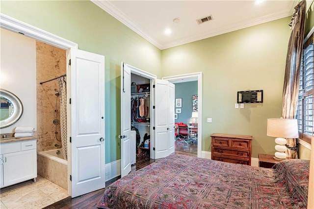 bedroom with crown molding, dark wood-style floors, a sink, baseboards, and connected bathroom
