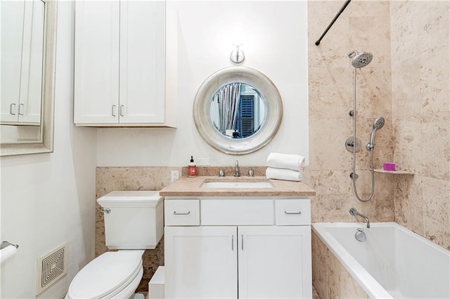 full bathroom featuring toilet, tiled shower / bath, and vanity