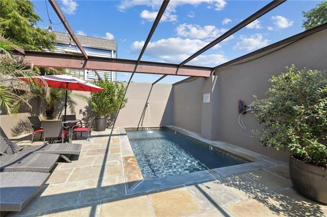 outdoor pool featuring a patio area, glass enclosure, and outdoor dining area