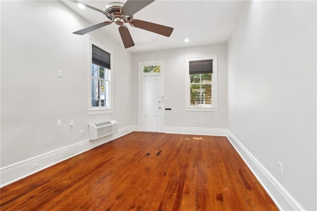 unfurnished room with an AC wall unit, wood finished floors, healthy amount of natural light, a ceiling fan, and recessed lighting