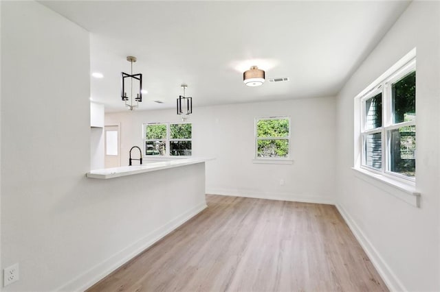 2004 Bluebird St, Slidell, LA 70460 - unfurnished living room with healthy amount of natural light, light wood finished floors, baseboards, and a sink