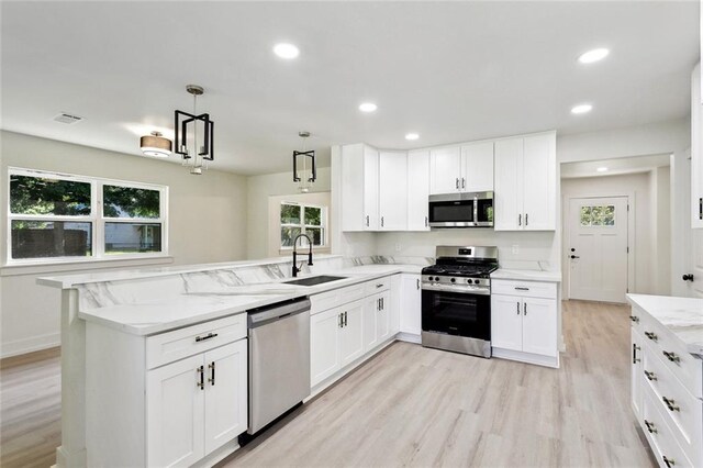 2004 Bluebird St, Slidell, LA 70460 - kitchen featuring appliances with stainless steel finishes, a sink, a peninsula, healthy amount of natural light, and recessed lighting