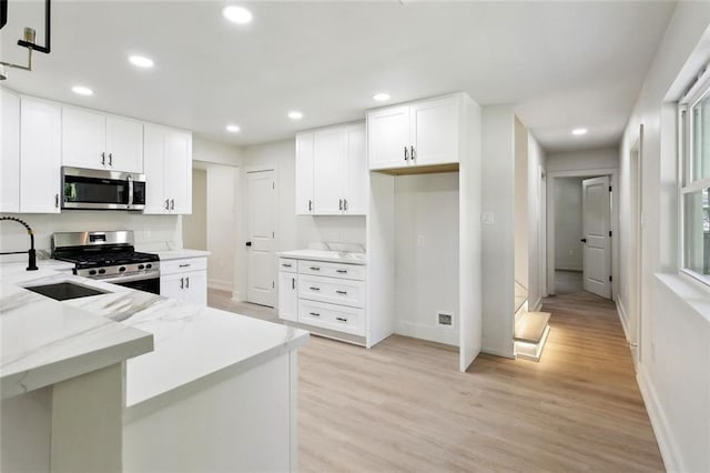 2004 Bluebird St, Slidell, LA 70460 - kitchen featuring stainless steel appliances, a sink, light wood finished floors, recessed lighting, and light stone countertops