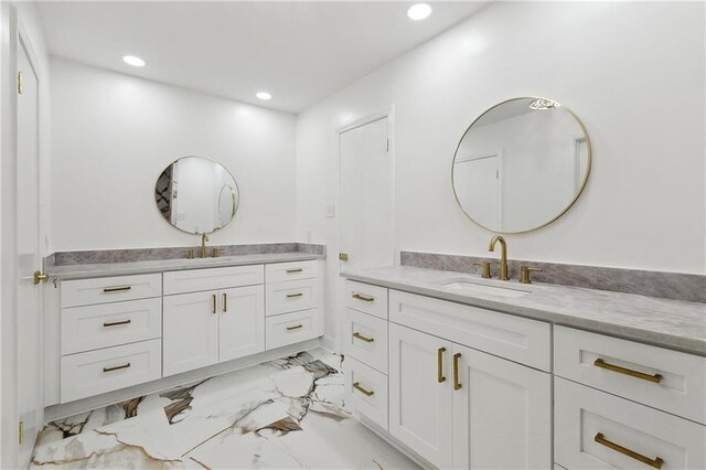 27 Yellowstone Dr, New Orleans, LA 70131 - bathroom featuring marble look tiles, two vanities, and recessed lighting