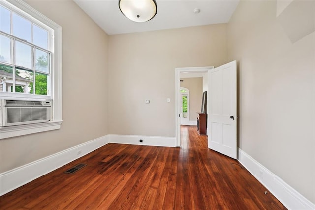 unfurnished room with hardwood / wood-style flooring, cooling unit, and baseboards