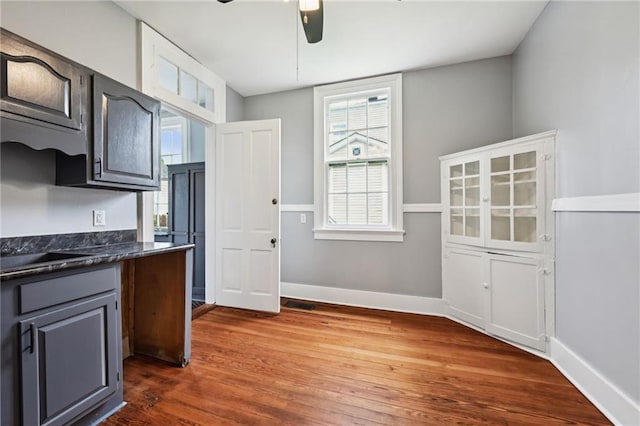kitchen with dark countertops, a ceiling fan, dark wood-style flooring, and plenty of natural light