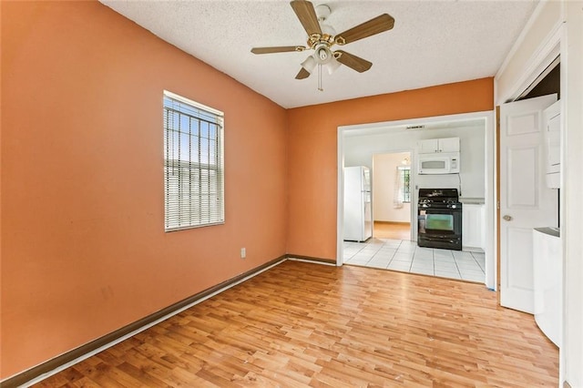 930 Andry St, New Orleans, LA 70117 - empty room with light wood-style flooring, ceiling fan, a textured ceiling, and baseboards