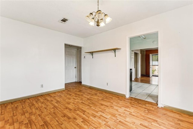 930 Andry St, New Orleans, LA 70117 - spare room with light wood finished floors, a chandelier, and baseboards