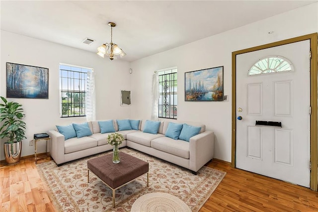 930 Andry St, New Orleans, LA 70117 - living room featuring light wood finished floors, a chandelier, electric panel, and baseboards