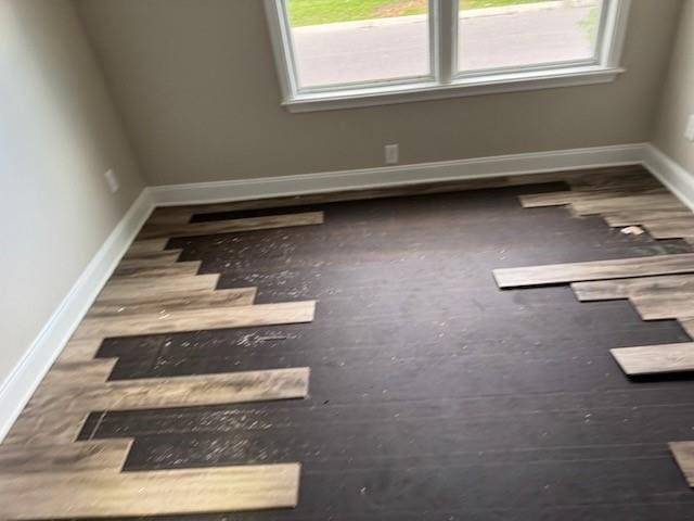 4701 Marais St, New Orleans, LA 70117 - empty room with plenty of natural light, baseboards, and wood finished floors