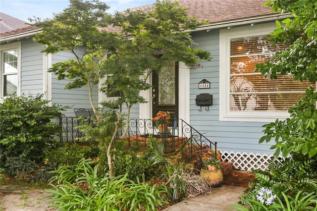 view of side of home with a shingled roof