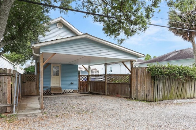 shotgun-style home featuring entry steps, fence, a gate, and driveway