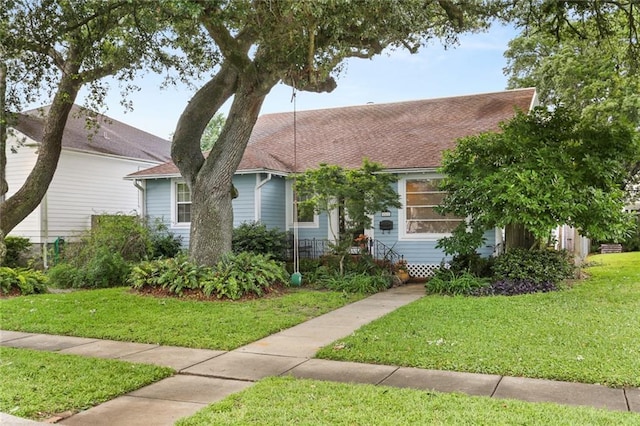 view of front of property featuring a front yard and roof with shingles
