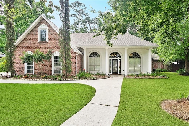 1306 Woodmere Dr, Mandeville, LA 70471 - view of front of property with a front lawn, roof with shingles, and brick siding