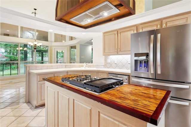1306 Woodmere Dr, Mandeville, LA 70471 - kitchen featuring appliances with stainless steel finishes, a sink, light tile patterned flooring, tasteful backsplash, and light brown cabinets