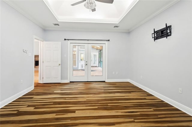 1306 Woodmere Dr, Mandeville, LA 70471 - empty room with wood finished floors, french doors, a tray ceiling, ceiling fan, and baseboards