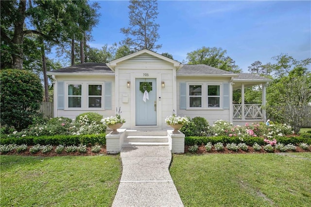 bungalow-style house with a front yard and roof with shingles