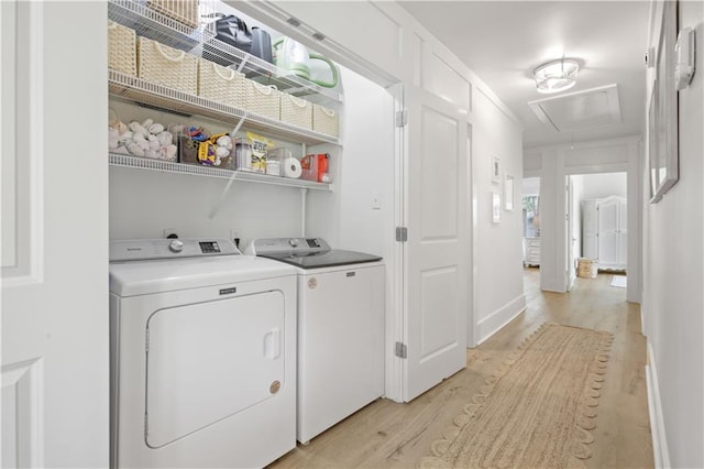 washroom with attic access, independent washer and dryer, and light wood-type flooring