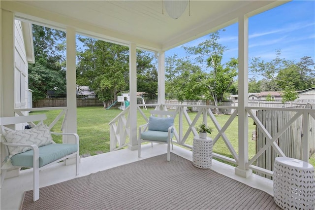 sunroom featuring ceiling fan and plenty of natural light