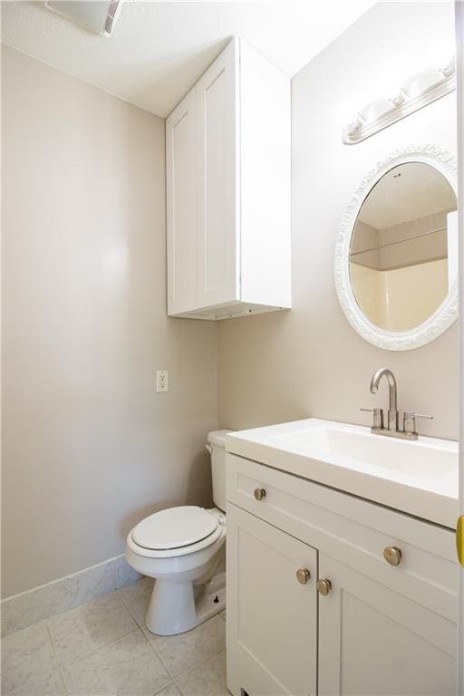 bathroom with vanity, toilet, and baseboards