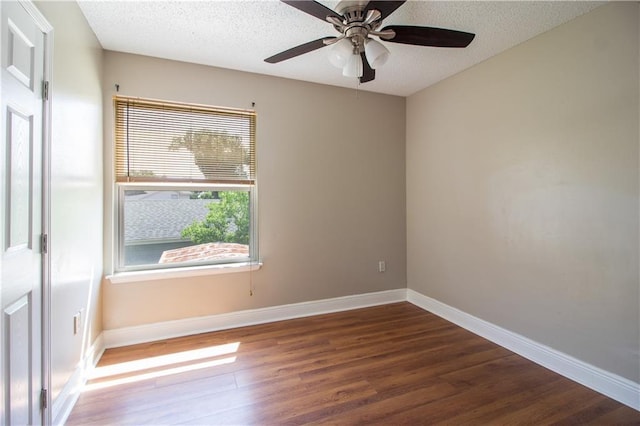 spare room featuring wood finished floors, a ceiling fan, a textured ceiling, and baseboards