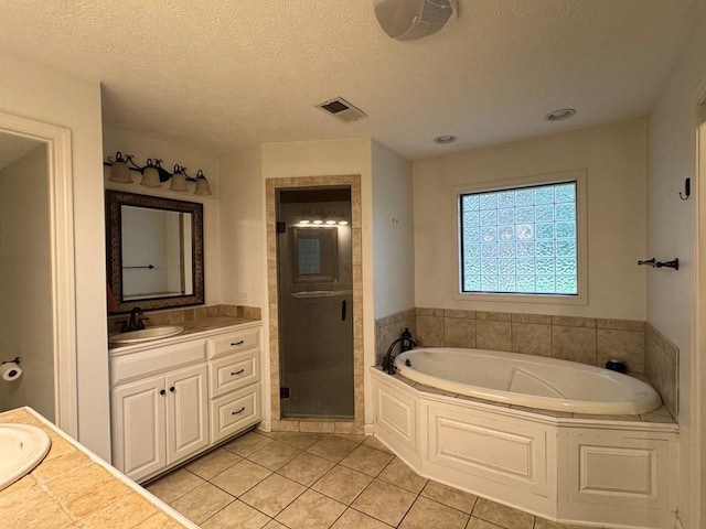 208 Noble Dr, Brookhaven, MS 39601 - bathroom featuring vanity, tile patterned flooring, a stall shower, a bath, and a textured ceiling