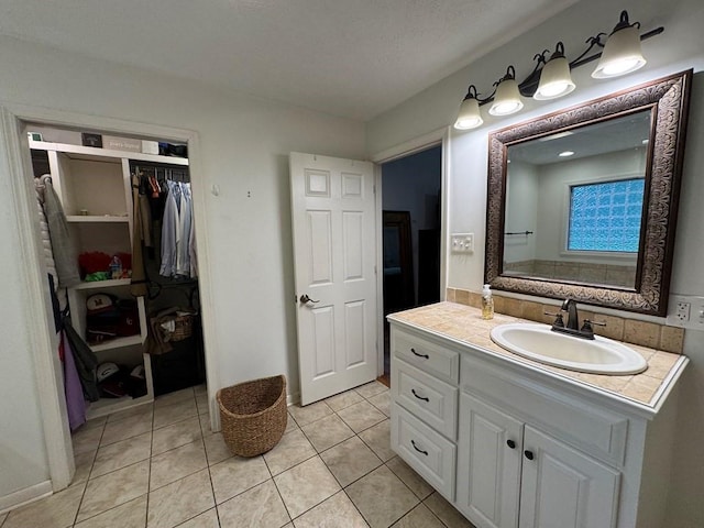 208 Noble Dr, Brookhaven, MS 39601 - full bathroom featuring vanity, tile patterned flooring, a walk in closet, and baseboards