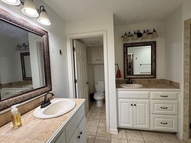 208 Noble Dr, Brookhaven, MS 39601 - full bath with toilet, tile patterned flooring, two vanities, and a textured ceiling