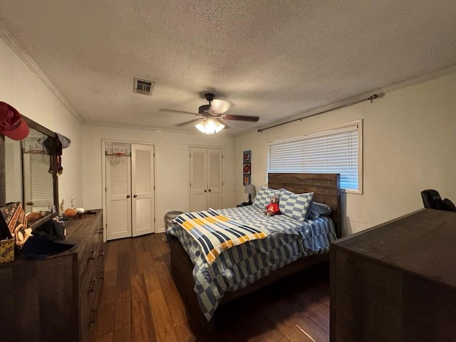 208 Noble Dr, Brookhaven, MS 39601 - bedroom with dark wood-style flooring, ornamental molding, a textured ceiling, multiple closets, and ceiling fan