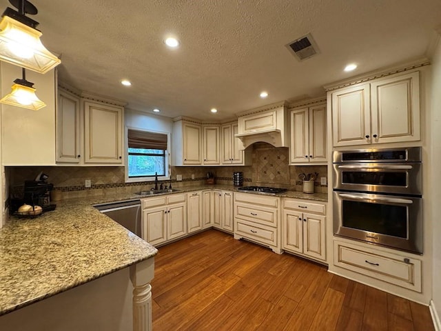208 Noble Dr, Brookhaven, MS 39601 - kitchen with appliances with stainless steel finishes, a sink, hardwood / wood-style flooring, recessed lighting, and premium range hood