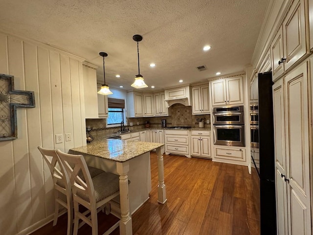 208 Noble Dr, Brookhaven, MS 39601 - kitchen with stainless steel appliances, dark wood-style flooring, a peninsula, a kitchen breakfast bar, and recessed lighting