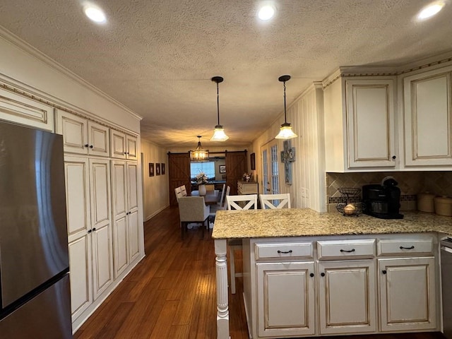 208 Noble Dr, Brookhaven, MS 39601 - kitchen featuring freestanding refrigerator, dark wood finished floors, a textured ceiling, recessed lighting, and a peninsula