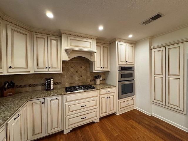 208 Noble Dr, Brookhaven, MS 39601 - kitchen with appliances with stainless steel finishes, dark wood-type flooring, tasteful backsplash, light stone counters, and baseboards