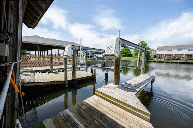 dock area featuring boat lift and a water view